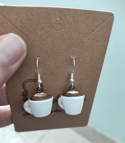Add a touch of whimsy to your outfit with these coffee mug charm earrings. Made with a porcelain mug on a silver hook, these earrings are approximately 1.25 inches long and weigh 0.16 oz. Perfect for the coffee lover in your life!
