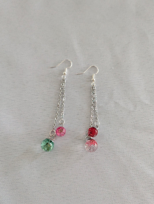 Pair of earrings with colorful beads on a light gray background