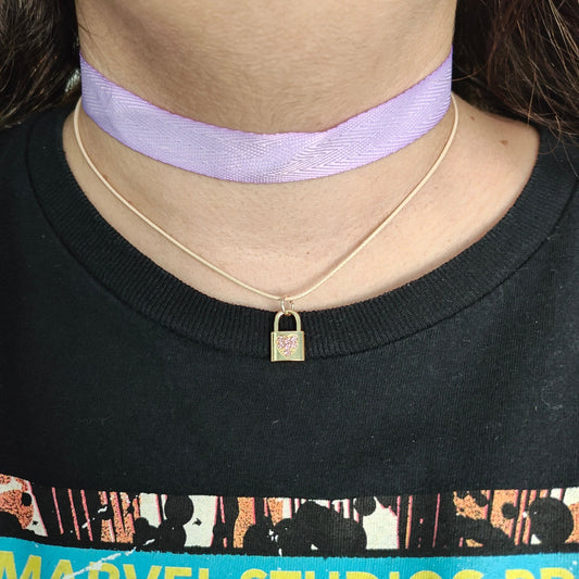 Elevate your style with our exquisite Necklace - Choker purple ribbon! Featuring a luxurious polyester strand and a dazzling gold charm with rhinestone lock, this statement piece is sure to turn heads. Add a touch of elegance and sophistication to any outfit with this stunning necklace.