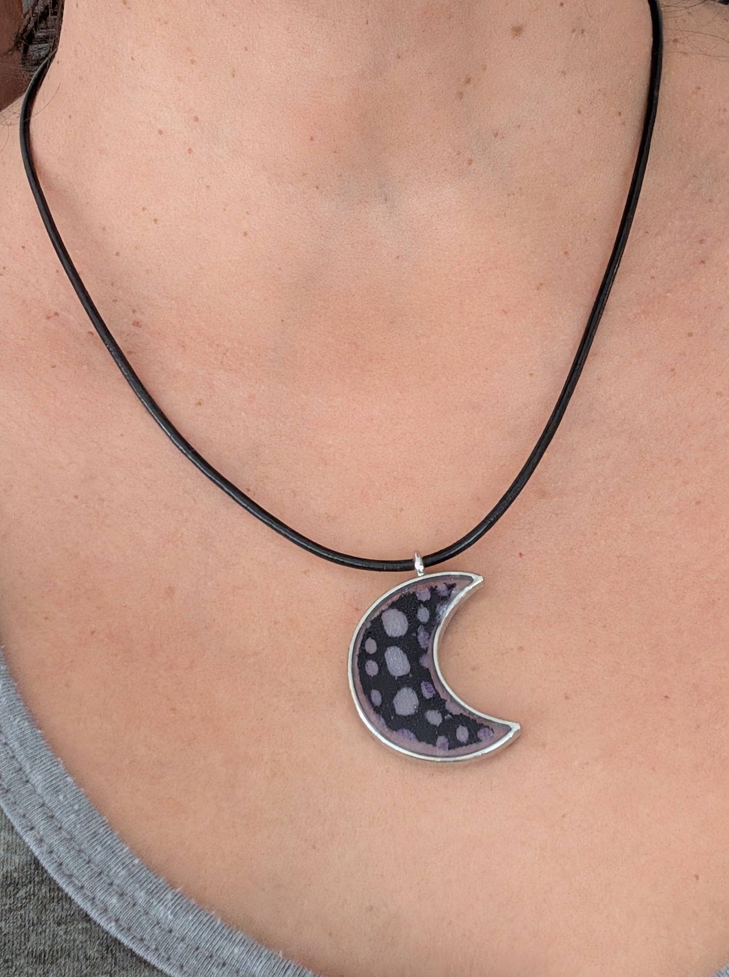 This stunning necklace features an 18-inch black leather cord with a resin silver moon pendant. The extension chain adds an extra 2 inches for the perfect fit. Lightweight at only 0.2 oz, this necklace will elevate any outfit. Feel passionate and inspired wearing this beautiful piece.