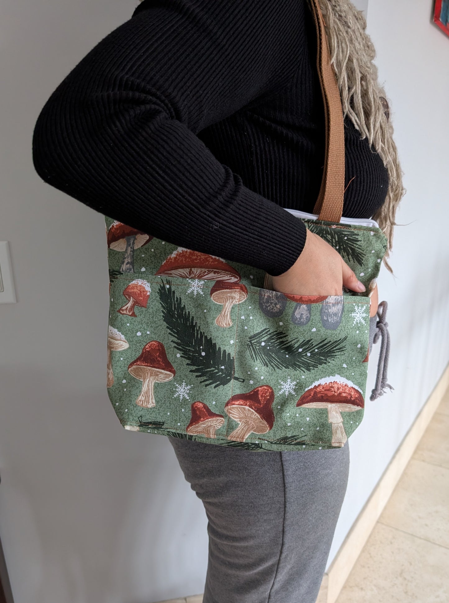 Snowy Mushrooms bag with orange lining two outer pockets one inner pocket and a zipper closure