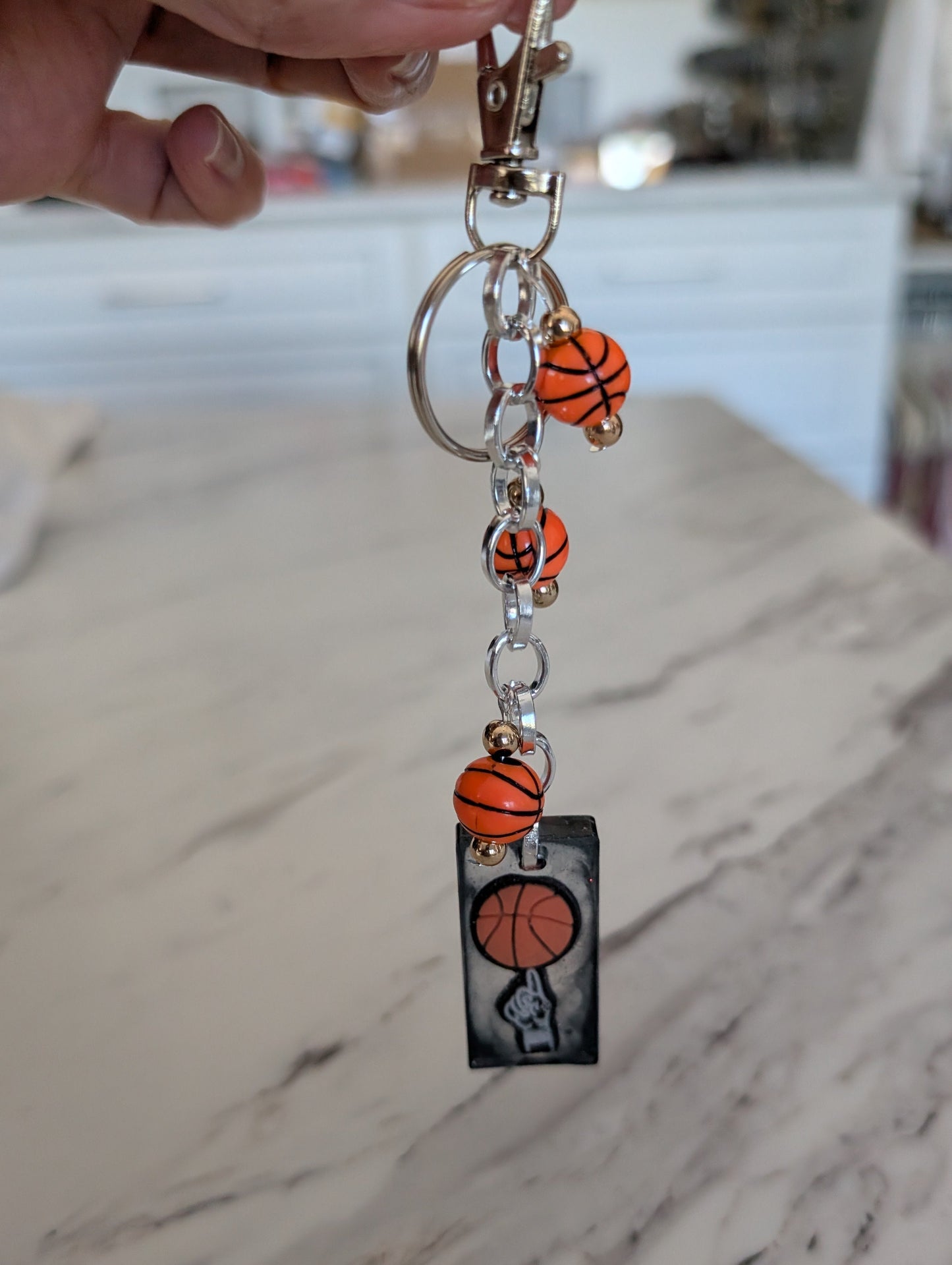 Keychain with basketball-themed beads on a marble surface