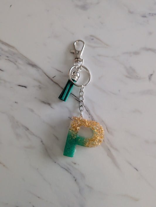 Keychain with letter 'P' on a marble surface