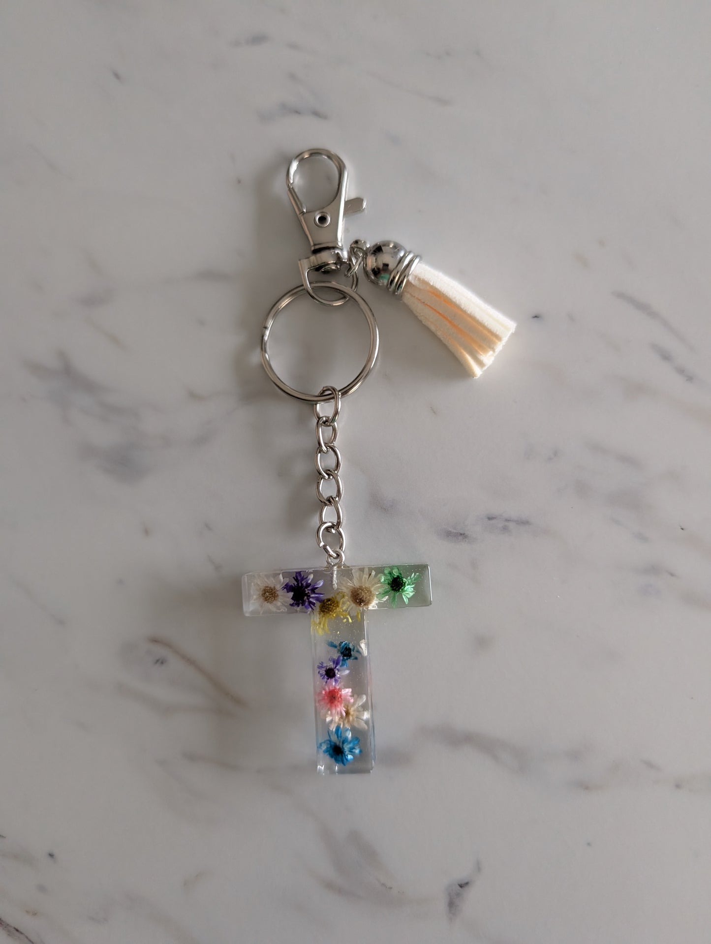 Letter T Keychain with floral design on a marble surface