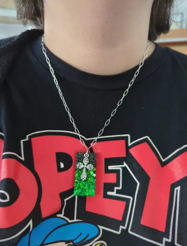 Necklace - 18.5 inches black green glitter resin rectangle with silver cross charm on silver paperclip cable chain