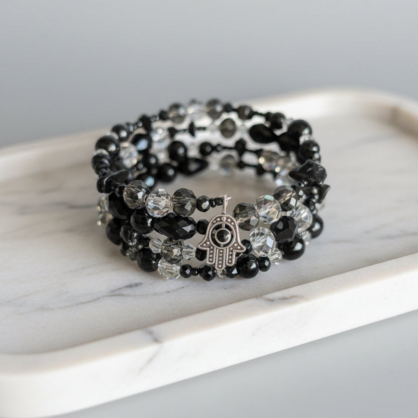 4 coil black and clear beaded bracelet on a marble surface
