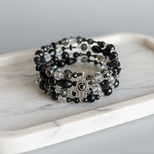 4 coil black and clear beaded bracelet on a marble surface