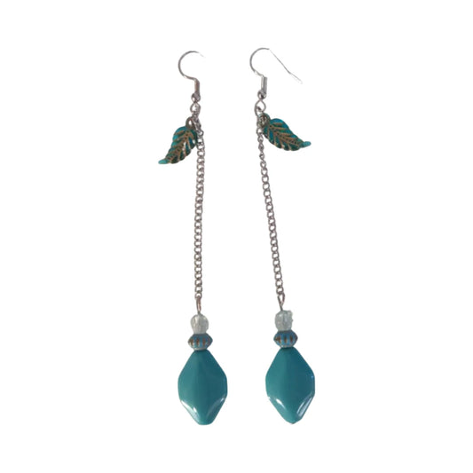 A pair of earrings featuring a blue leaf charm, a large smooth blue bead, one small textured clear bead, and one small textured blue bead, attached to silver chain hooks.