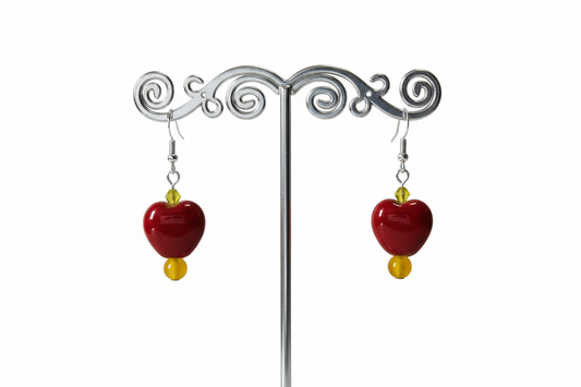 A pair of chunky heart-shaped bead earrings with yellow and red colors and crystal beads on a silver hook.