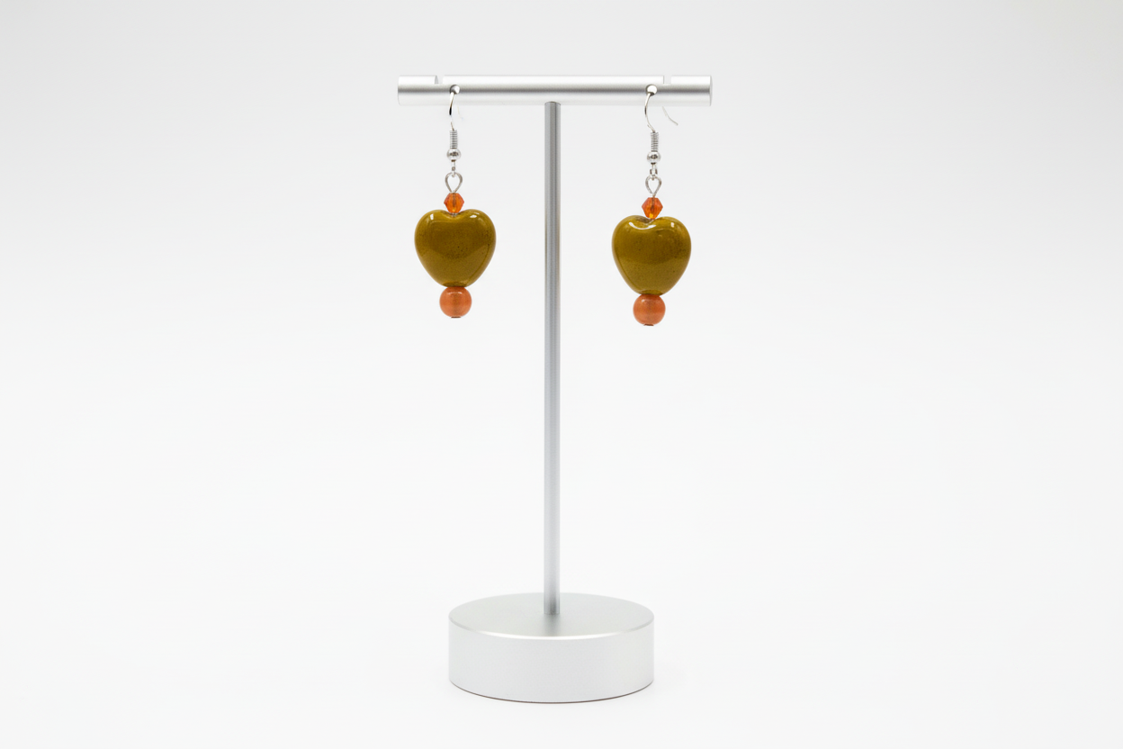 A pair of chunky heart-shaped bead earrings with crystal beads, attached to hooks.