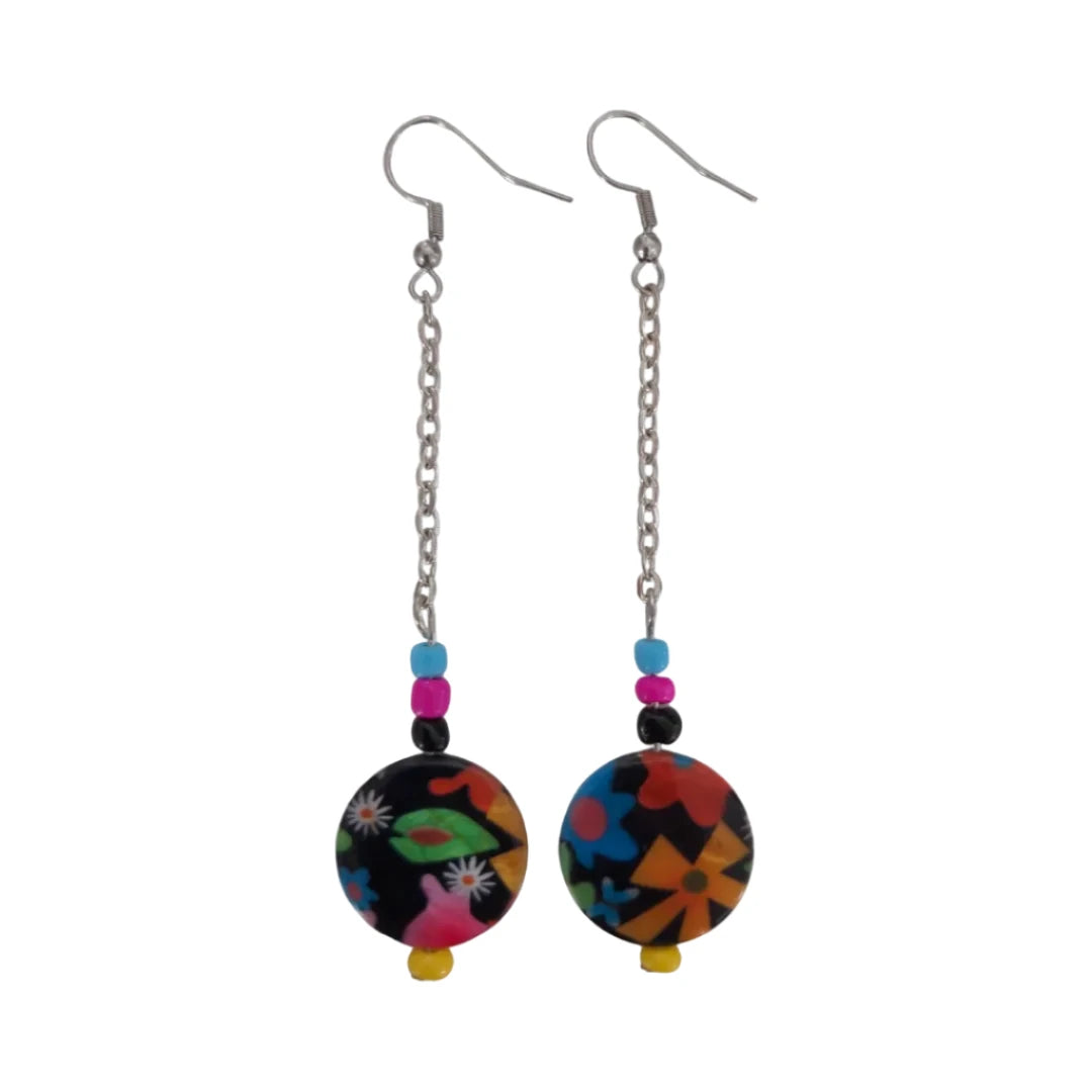 A pair of earrings featuring a colorful floral disc shell bead on a silver chain with drop hooks.