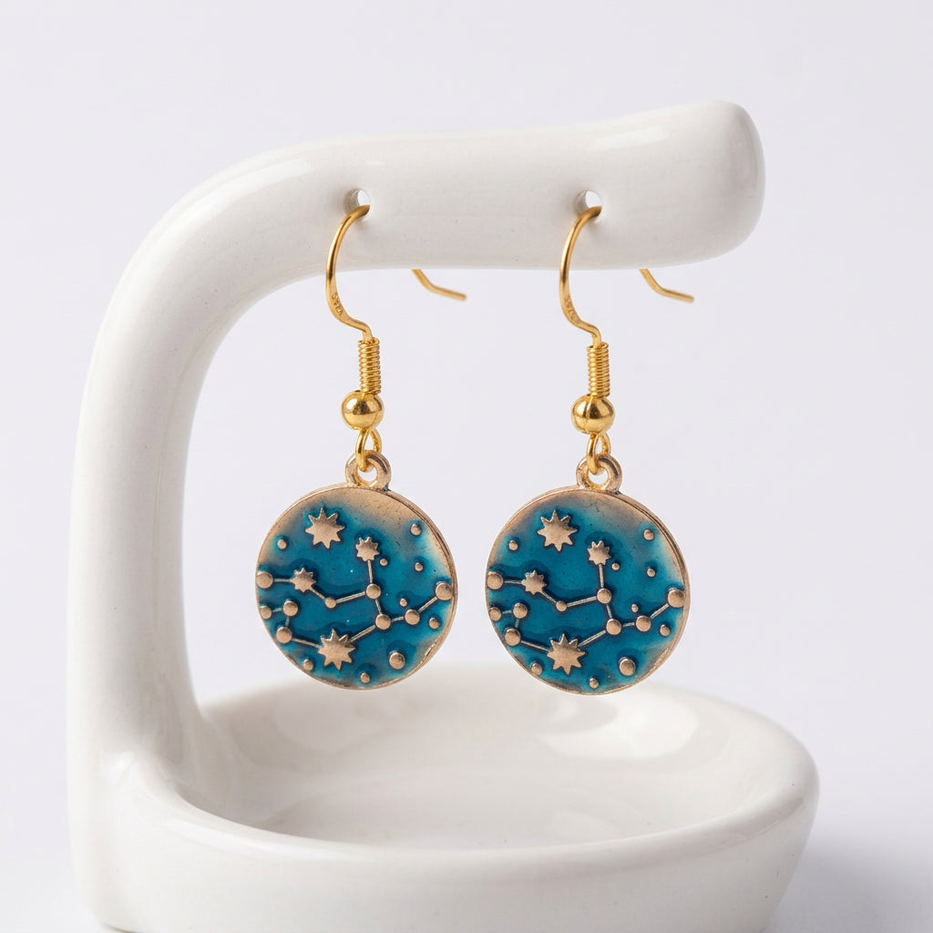 A pair of gold-plated blue earrings with a constellation pattern and gold hooks.