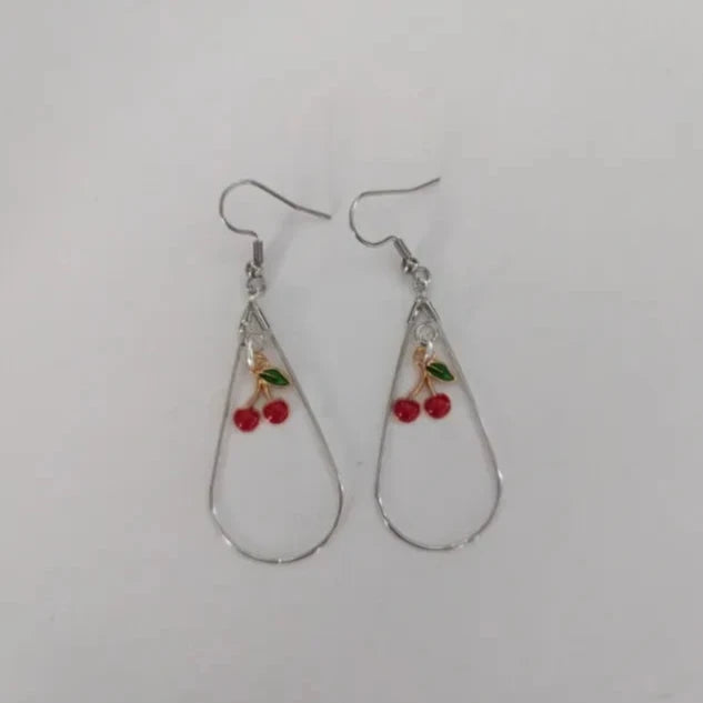 A pair of silver tear drop earrings with gold plated cherries on hooks.