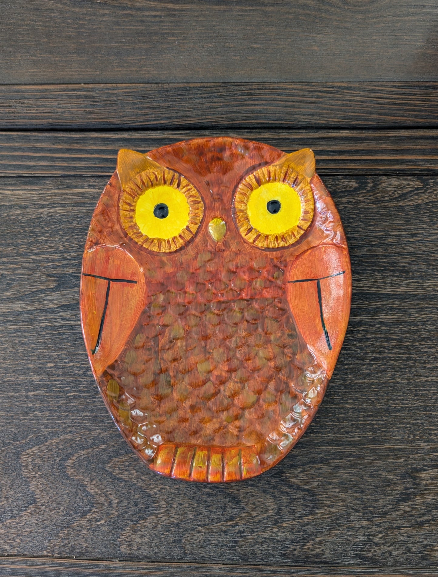 Decorative owl plate on a wooden surface