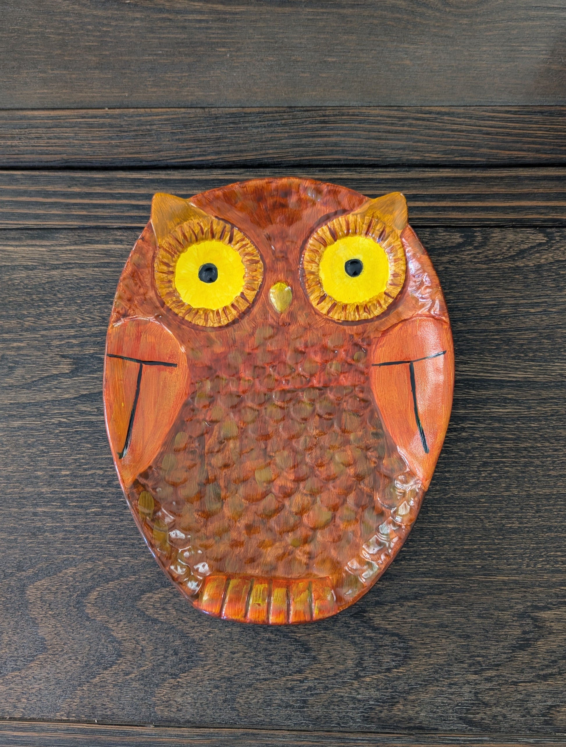Decorative owl plate on a wooden surface