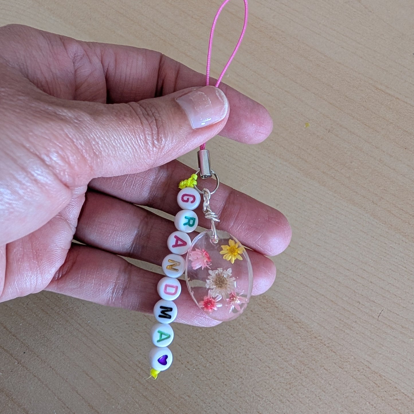 Spice up your phone with this charming resin charm, adorned with real dried flowers and beads. The 3.75 inch length adds a touch of flair to any device. (It's like a bouquet, but for your phone!)

Phone charm - Resin charm with dried flowers and beads