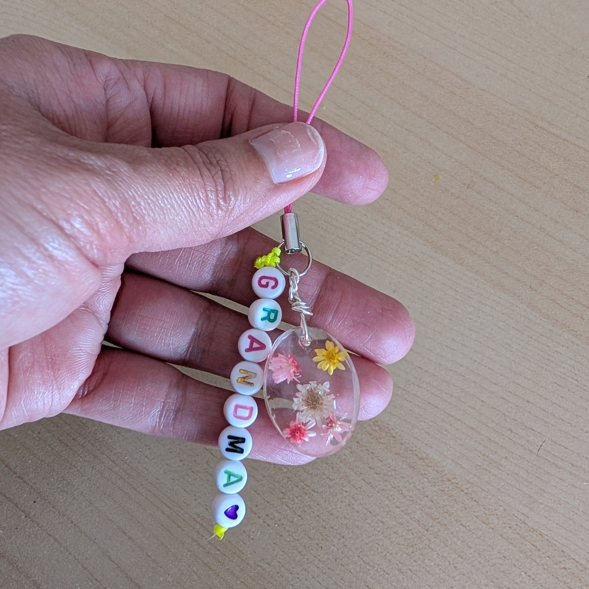 Spice up your phone with this charming resin charm, adorned with real dried flowers and beads. The 3.75 inch length adds a touch of flair to any device. (It's like a bouquet, but for your phone!)

Phone charm - Resin charm with dried flowers and beads