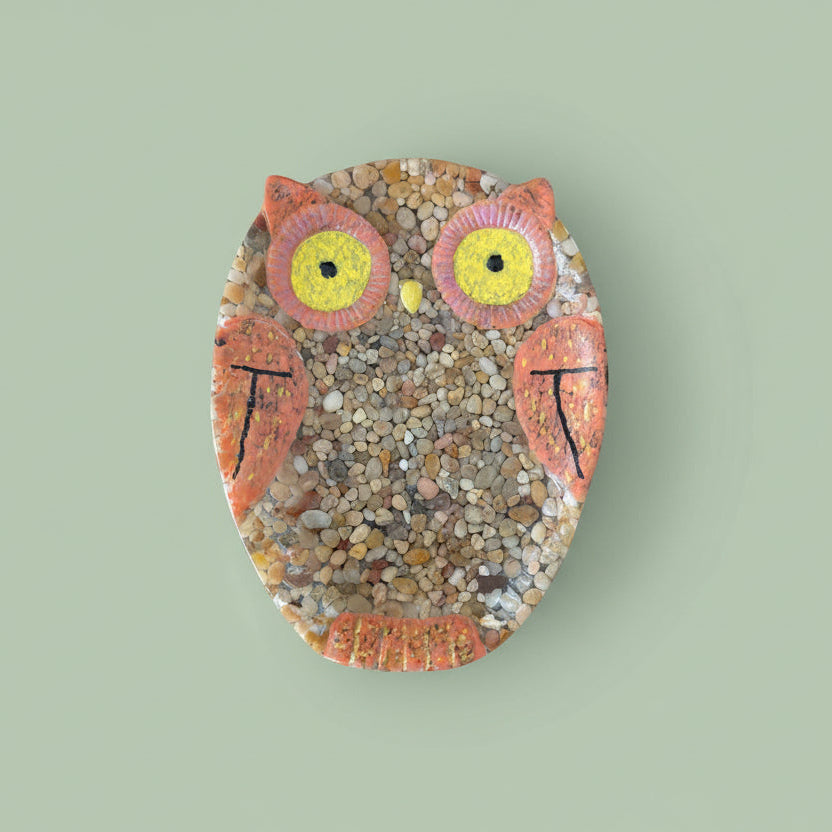 Decorative resin with rocks owl trinket dish on a light green background