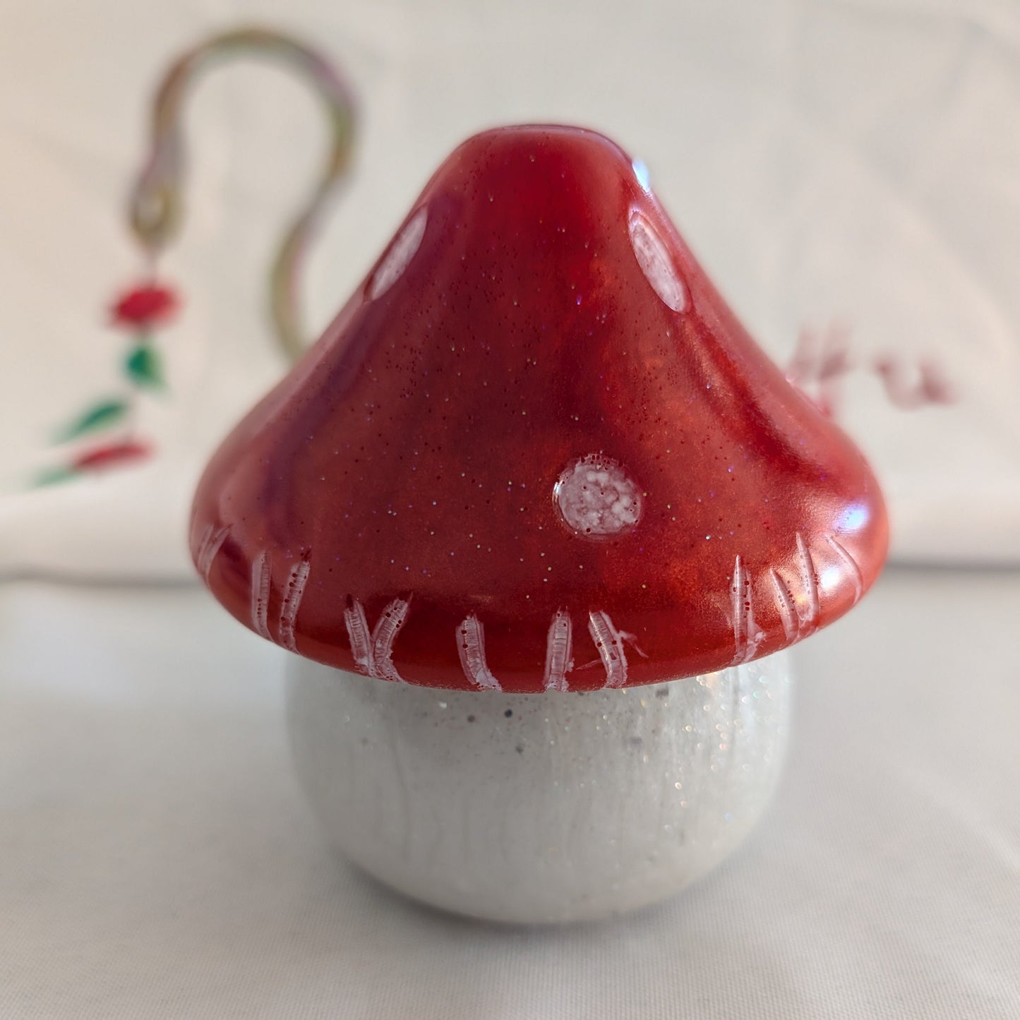 This charming hand-crafted resin mushroom trinket brings whimsical elegance to any space. Meticulously sculpted from epoxy resin, it features a smooth, glass-like finish that's both durable and non-porous—perfect for storing small treasures, jewelry, or keepsakes. The removable lid makes access effortless, while its compact 4.5-inch height and 4x4-inch width fit seamlessly on shelves, desks, or nightstands. At just 12.4 ounces, it's lightweight yet substantial enough to feel premium. Each piece showcases th