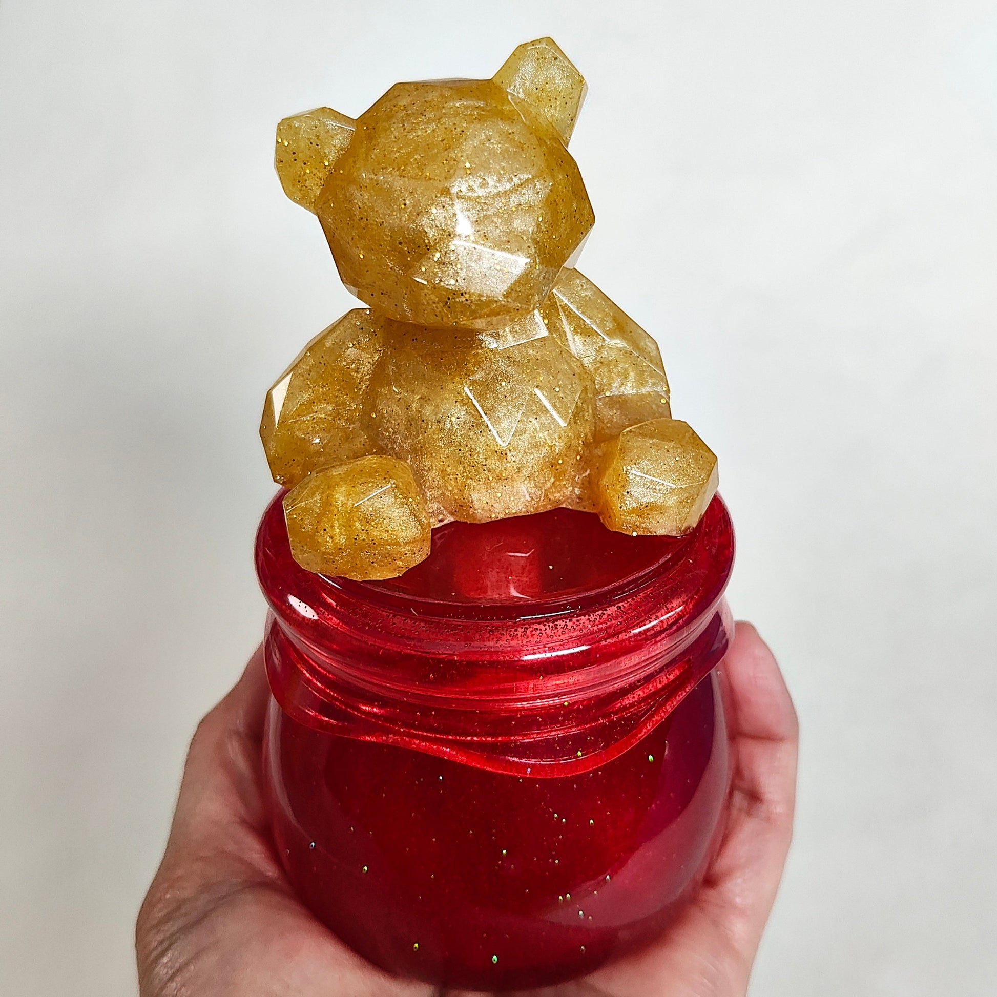 Add a touch of whimsy to your home with our Knickknack - Resin Jar. Featuring a playful bear screw on lid, this jar is perfect for storing small items. Measuring 2.75 x 2.75 inches with a height of 5 inches and a weight of 7.8 oz, it's both functional and fun!

Resin Jar with bear screw on lid