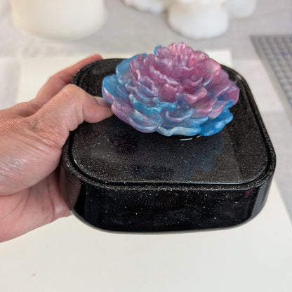 Elevate your jewelry collection with this stunning Knickknack jewelry box. Featuring a flower lid and made of durable resin, this box measures 5 x 5 inches and has a depth of 1.5 inches, making it perfect for large pieces. Weighing only 14 oz, it's also lightweight and easy to transport. Transform your dressing table and protect your precious pieces with this beautiful box.