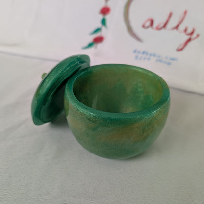 hand crafted with epoxy resin..

Epoxy resin is typically smooth, rigid, and non-porous, similar to a hard plastic or glass.

Knickknack - Resin apple trinket with lid