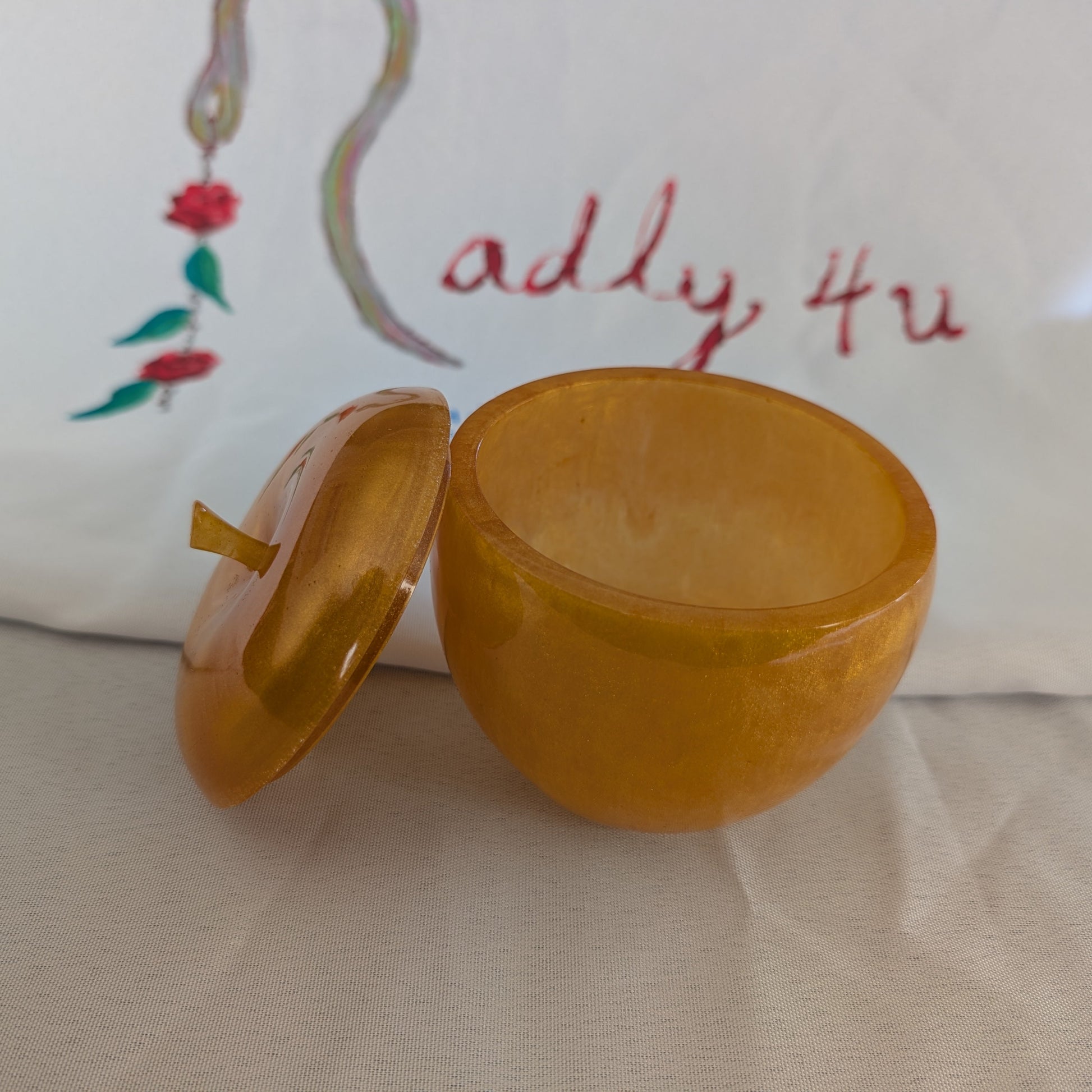 hand crafted with epoxy resin..

Epoxy resin is typically smooth, rigid, and non-porous, similar to a hard plastic or glass.

Knickknack - Resin apple trinket with lid