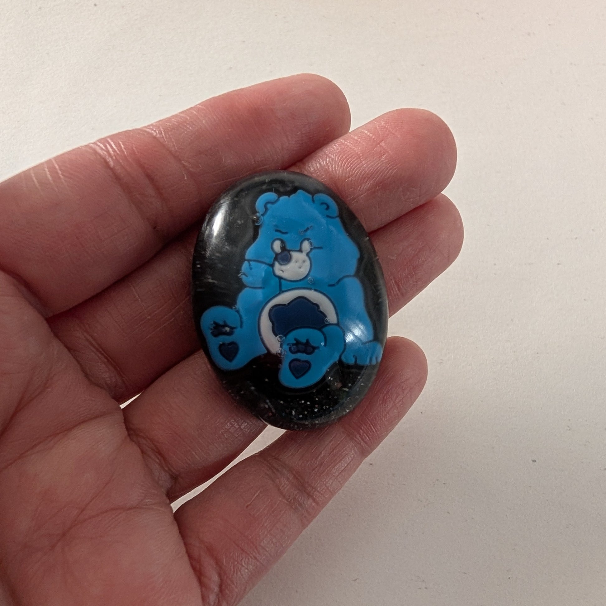 This 3D Care Bears resin pin adds a playful and nostalgic touch to any outfit or accessory. Crafted with detailed resin and secured by a silver butterfly clutch, it ensures both style and durability. Perfect for collectors or fans looking to brighten their day with a charming, wearable keepsake.