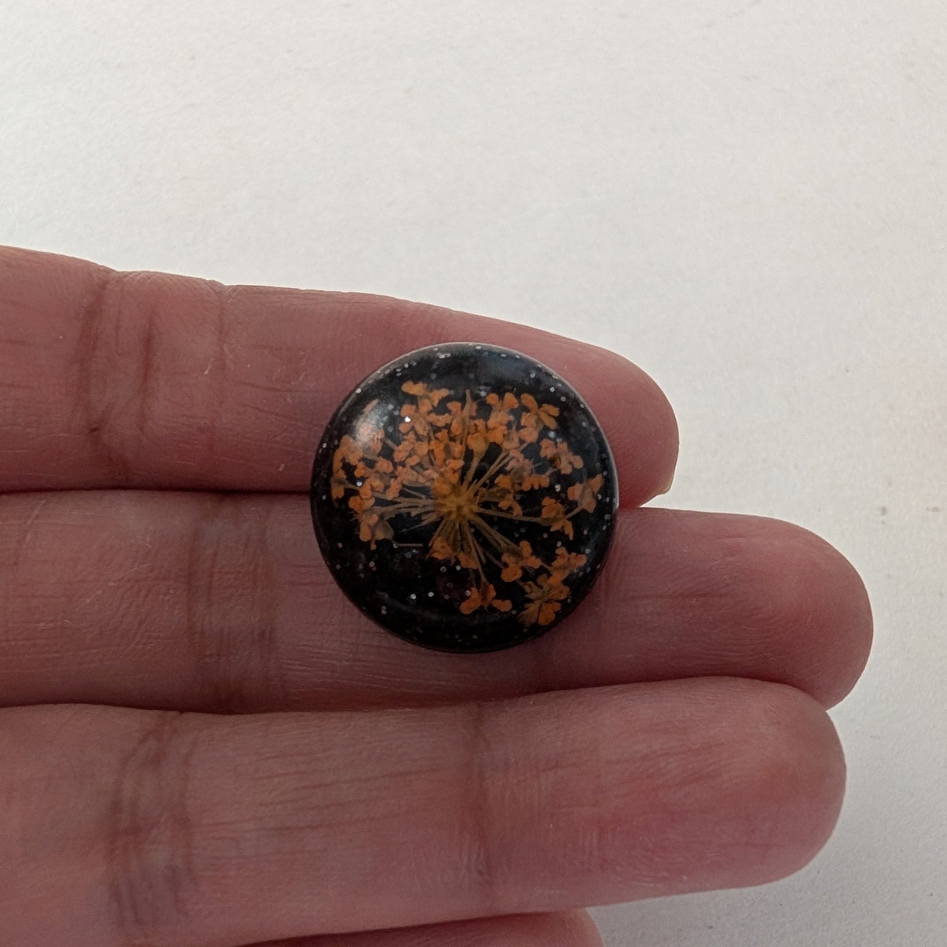 Add a touch of nature to your outfit with our Pin - 3D dried flower resin pin. The intricate design and 3D effect will surely catch everyone's eye. With the sturdy silver butterfly clutch, your pin will stay securely in place. Elevate your style with this unique and beautiful accessory.