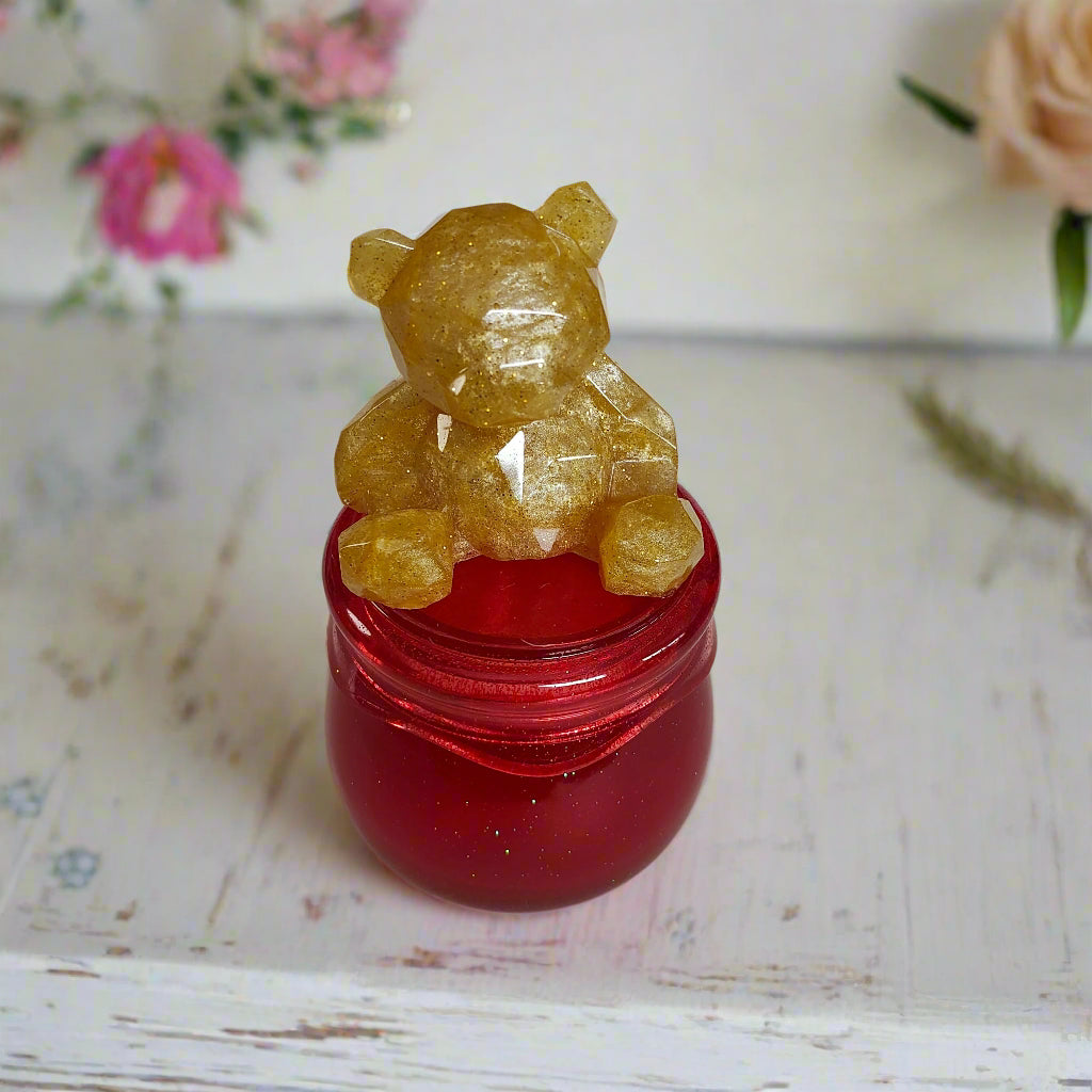 Add a touch of whimsy to your home with our Knickknack - Resin Jar. Featuring a playful bear screw on lid, this jar is perfect for storing small items. Measuring 2.75 x 2.75 inches with a height of 5 inches and a weight of 7.8 oz, it's both functional and fun!

Resin Jar with bear screw on lid