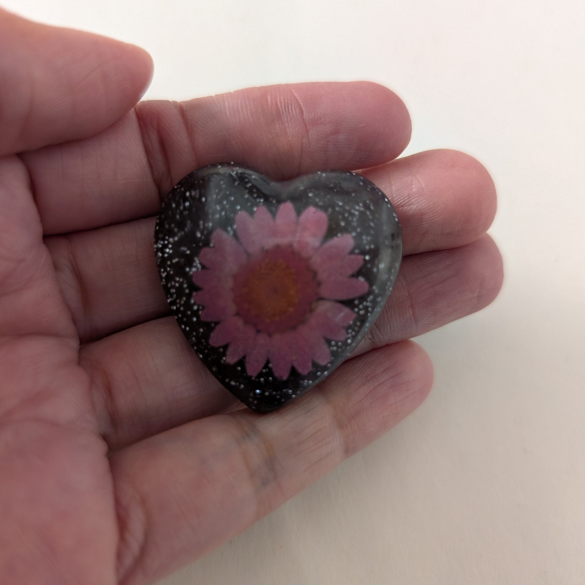 Add a touch of whimsy to any outfit with our 3D dried flower in resin pin. The stunning silver butterfly clutch ensures secure and easy attachment. Let this pin be your new go-to accessory for an elevated and playful look!