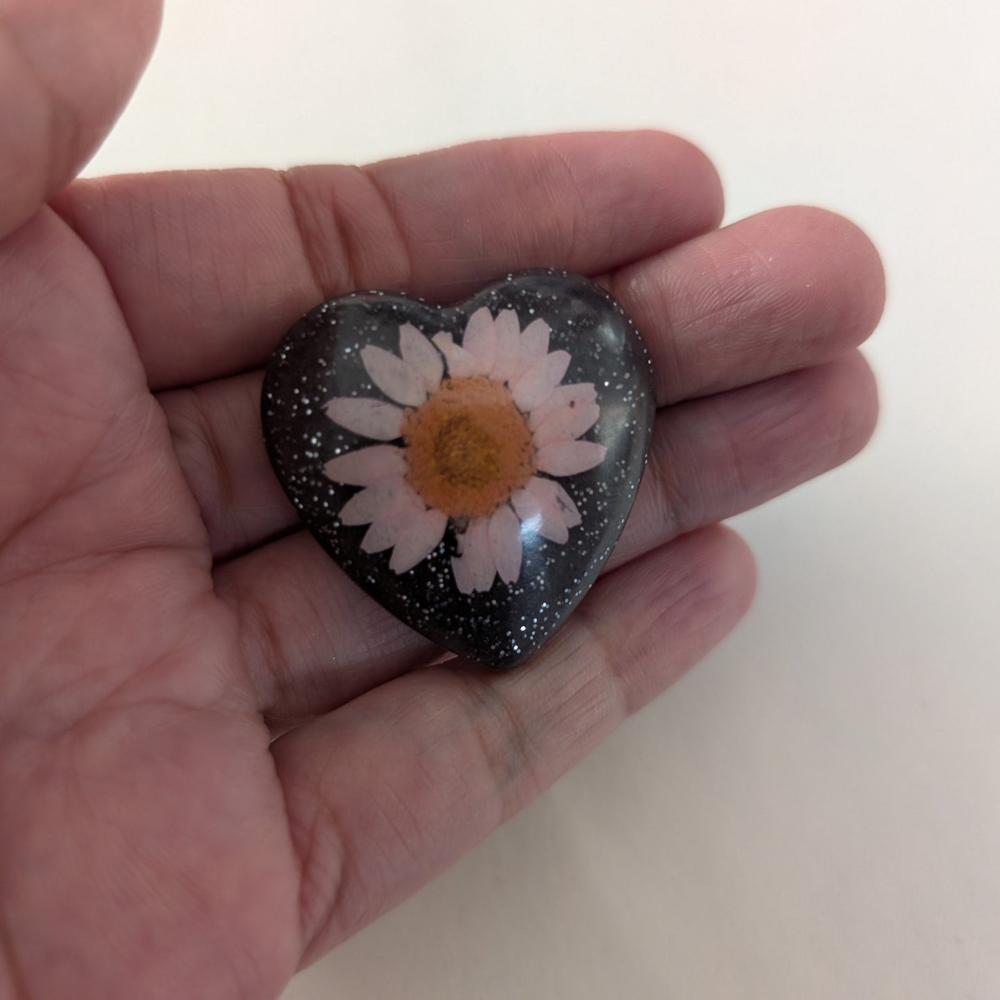 Add a touch of whimsy to any outfit with our 3D dried flower in resin pin. The stunning silver butterfly clutch ensures secure and easy attachment. Let this pin be your new go-to accessory for an elevated and playful look!