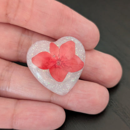 Add a touch of nature to your outfit with our Pin - 3D dried flower resin pin. The intricate design and 3D effect will surely catch everyone's eye. With the sturdy silver butterfly clutch, your pin will stay securely in place. Elevate your style with this unique and beautiful accessory.