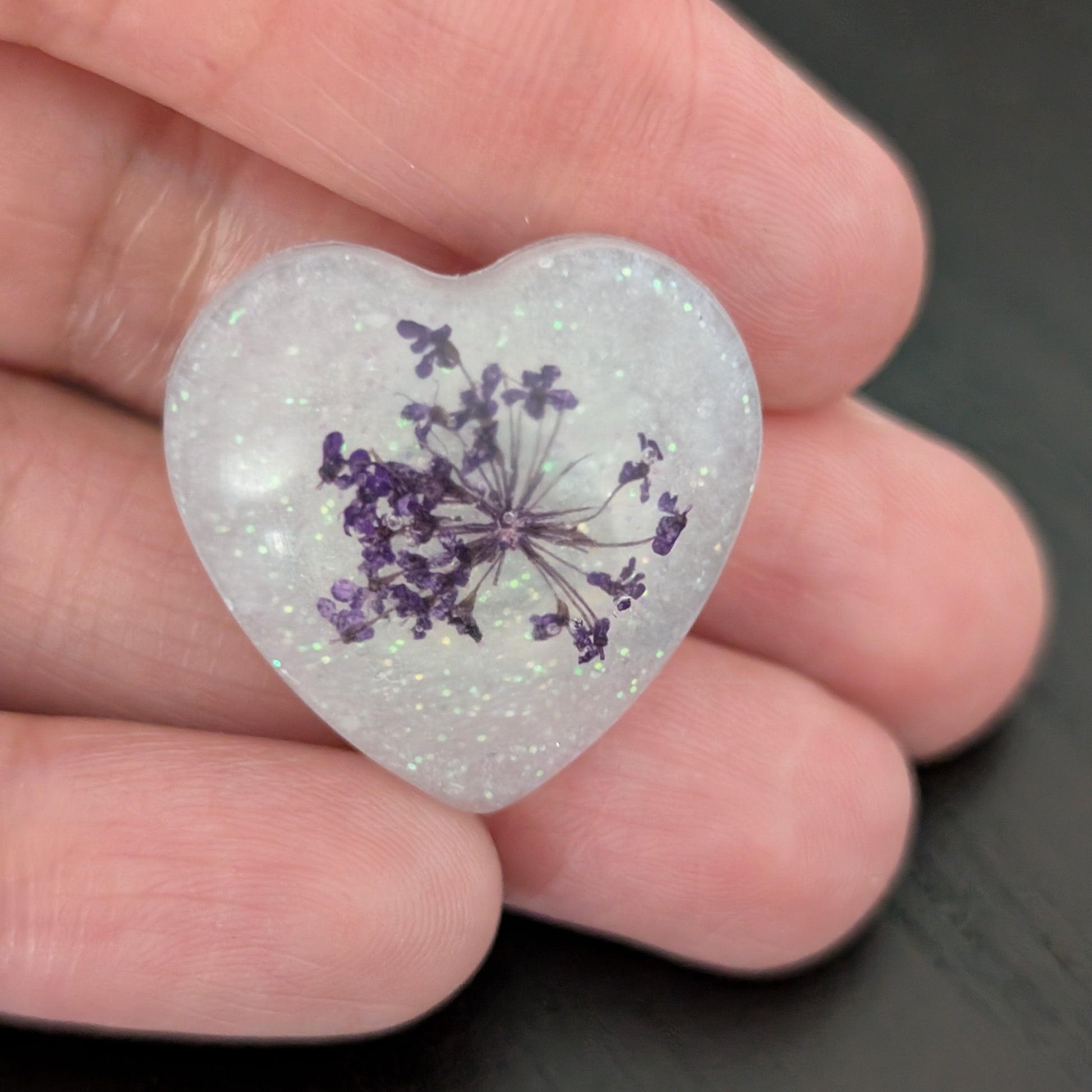 Add a touch of nature to your outfit with our Pin - 3D dried flower resin pin. The intricate design and 3D effect will surely catch everyone's eye. With the sturdy silver butterfly clutch, your pin will stay securely in place. Elevate your style with this unique and beautiful accessory.