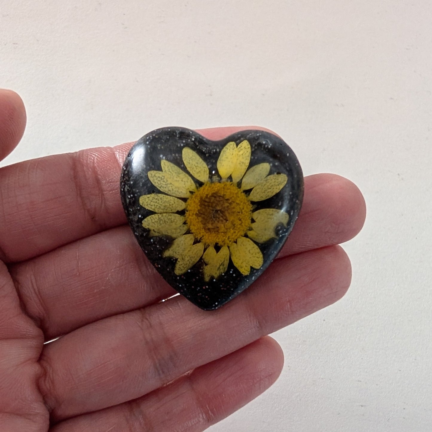 Add a touch of whimsy to any outfit with our 3D dried flower in resin pin. The stunning silver butterfly clutch ensures secure and easy attachment. Let this pin be your new go-to accessory for an elevated and playful look!