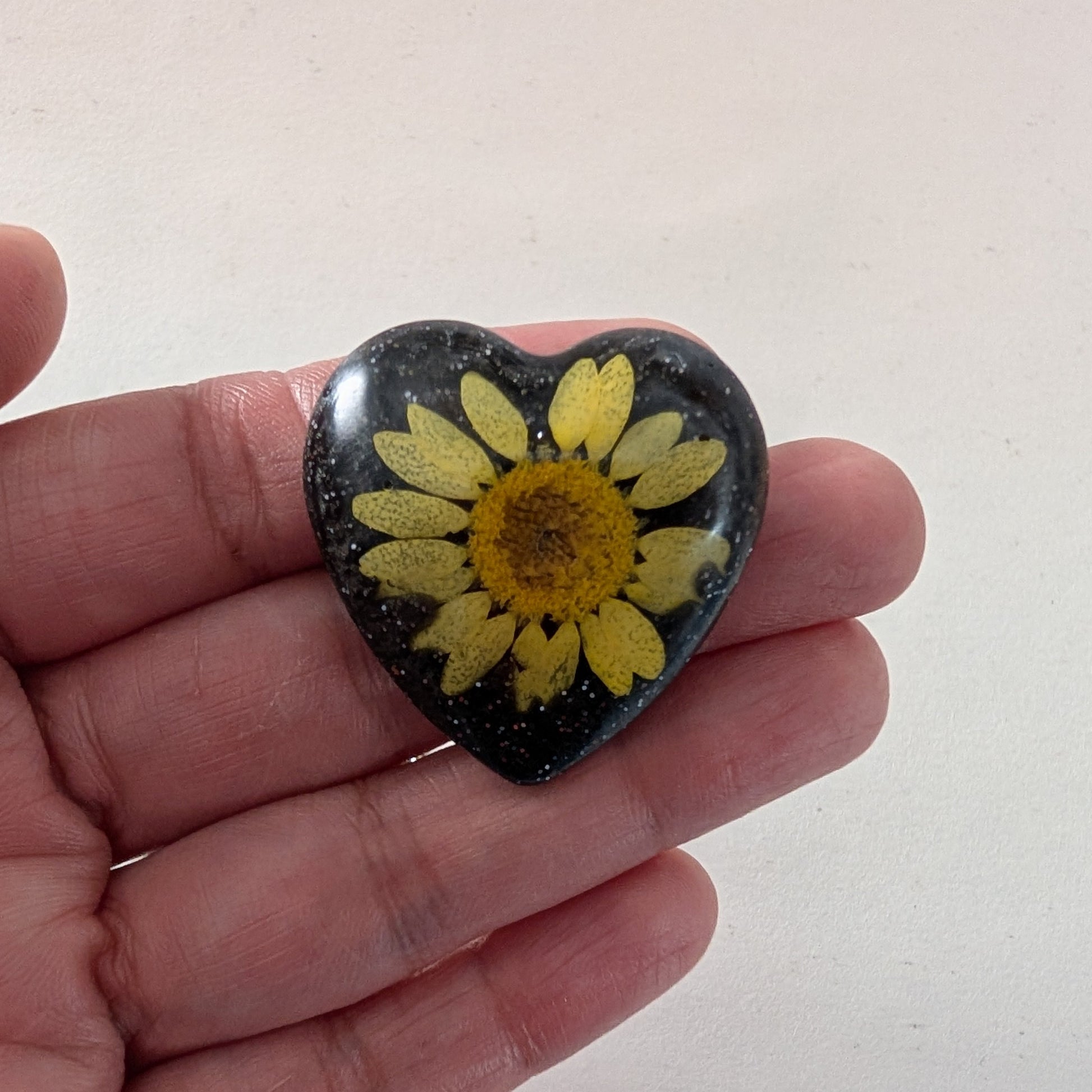 Add a touch of whimsy to any outfit with our 3D dried flower in resin pin. The stunning silver butterfly clutch ensures secure and easy attachment. Let this pin be your new go-to accessory for an elevated and playful look!