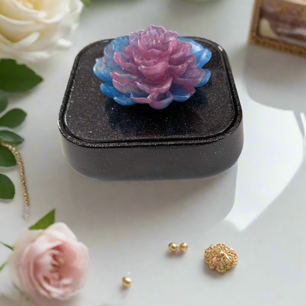 Elevate your jewelry collection with this stunning Knickknack jewelry box. Featuring a flower lid and made of durable resin, this box measures 5 x 5 inches and has a depth of 1.5 inches, making it perfect for large pieces. Weighing only 14 oz, it's also lightweight and easy to transport. Transform your dressing table and protect your precious pieces with this beautiful box.