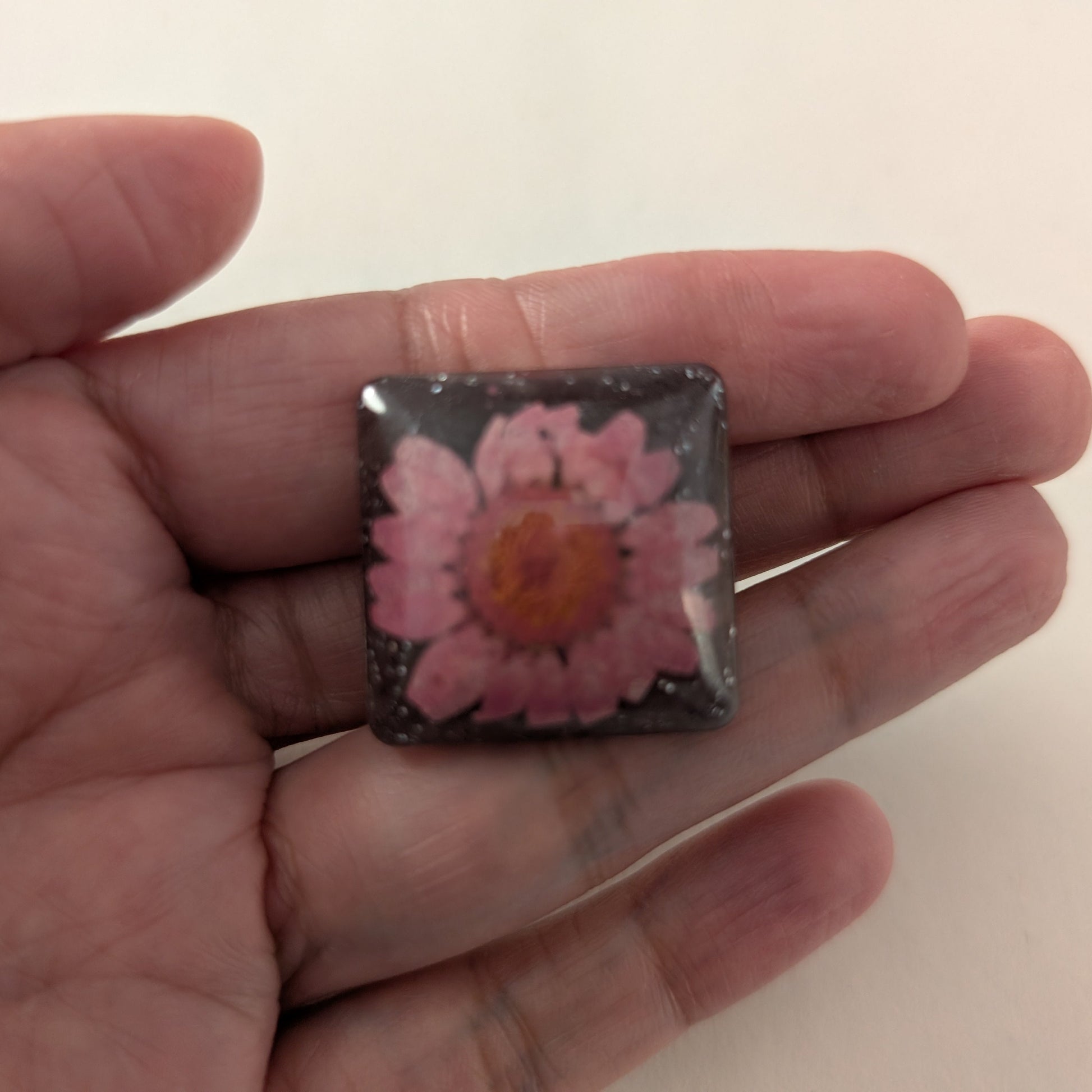 Add a touch of whimsy to any outfit with our 3D dried flower in resin pin. The stunning silver butterfly clutch ensures secure and easy attachment. Let this pin be your new go-to accessory for an elevated and playful look!