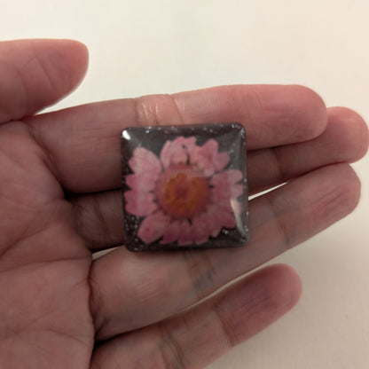 Add a touch of whimsy to any outfit with our 3D dried flower in resin pin. The stunning silver butterfly clutch ensures secure and easy attachment. Let this pin be your new go-to accessory for an elevated and playful look!