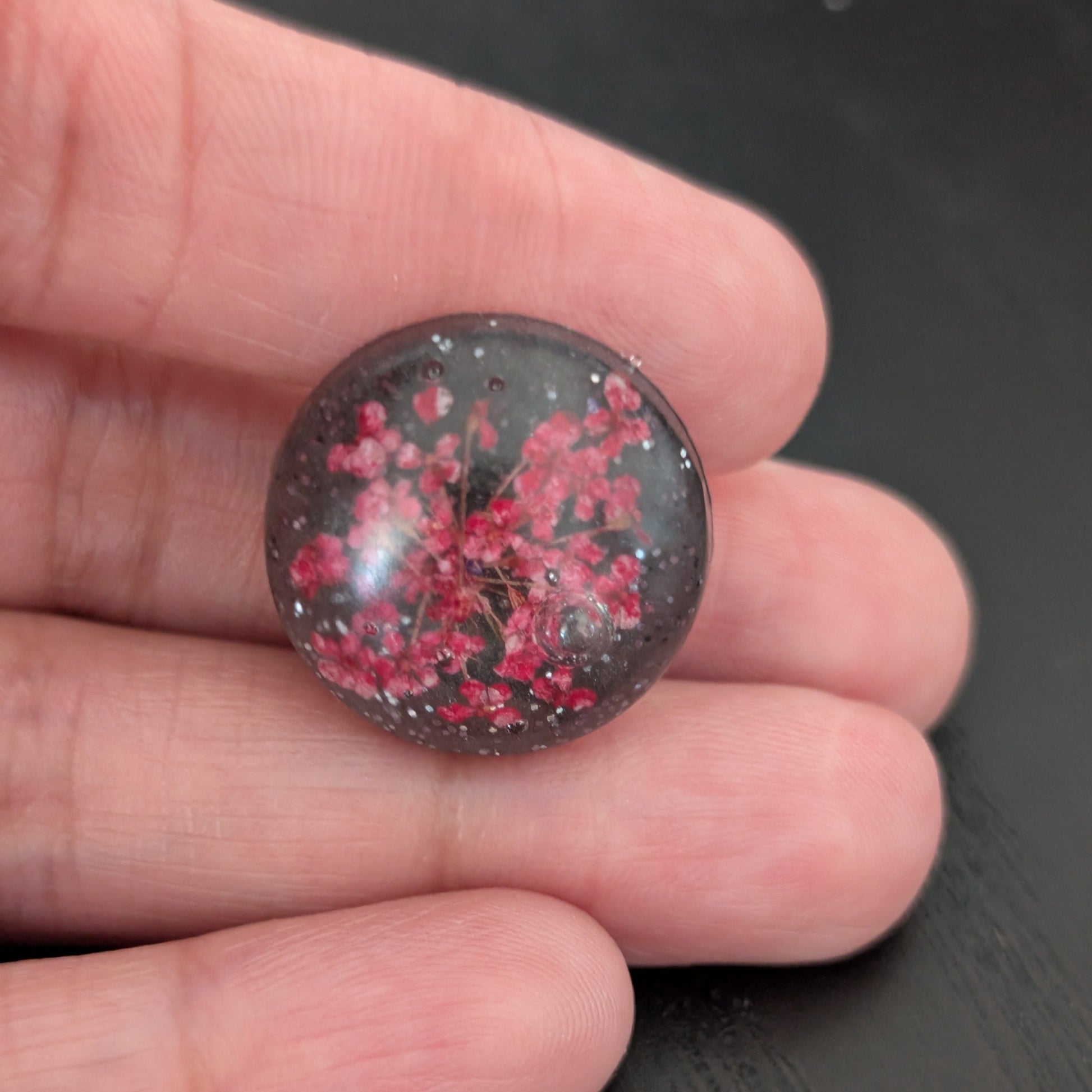 Add a touch of nature to your outfit with our Pin - 3D dried flower resin pin. The intricate design and 3D effect will surely catch everyone's eye. With the sturdy silver butterfly clutch, your pin will stay securely in place. Elevate your style with this unique and beautiful accessory.