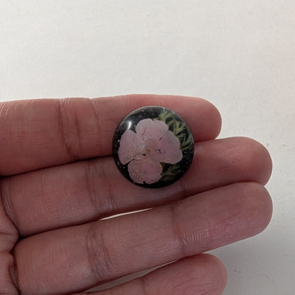 Add a touch of nature to your outfit with our Pin - 3D dried flower resin pin. The intricate design and 3D effect will surely catch everyone's eye. With the sturdy silver butterfly clutch, your pin will stay securely in place. Elevate your style with this unique and beautiful accessory.