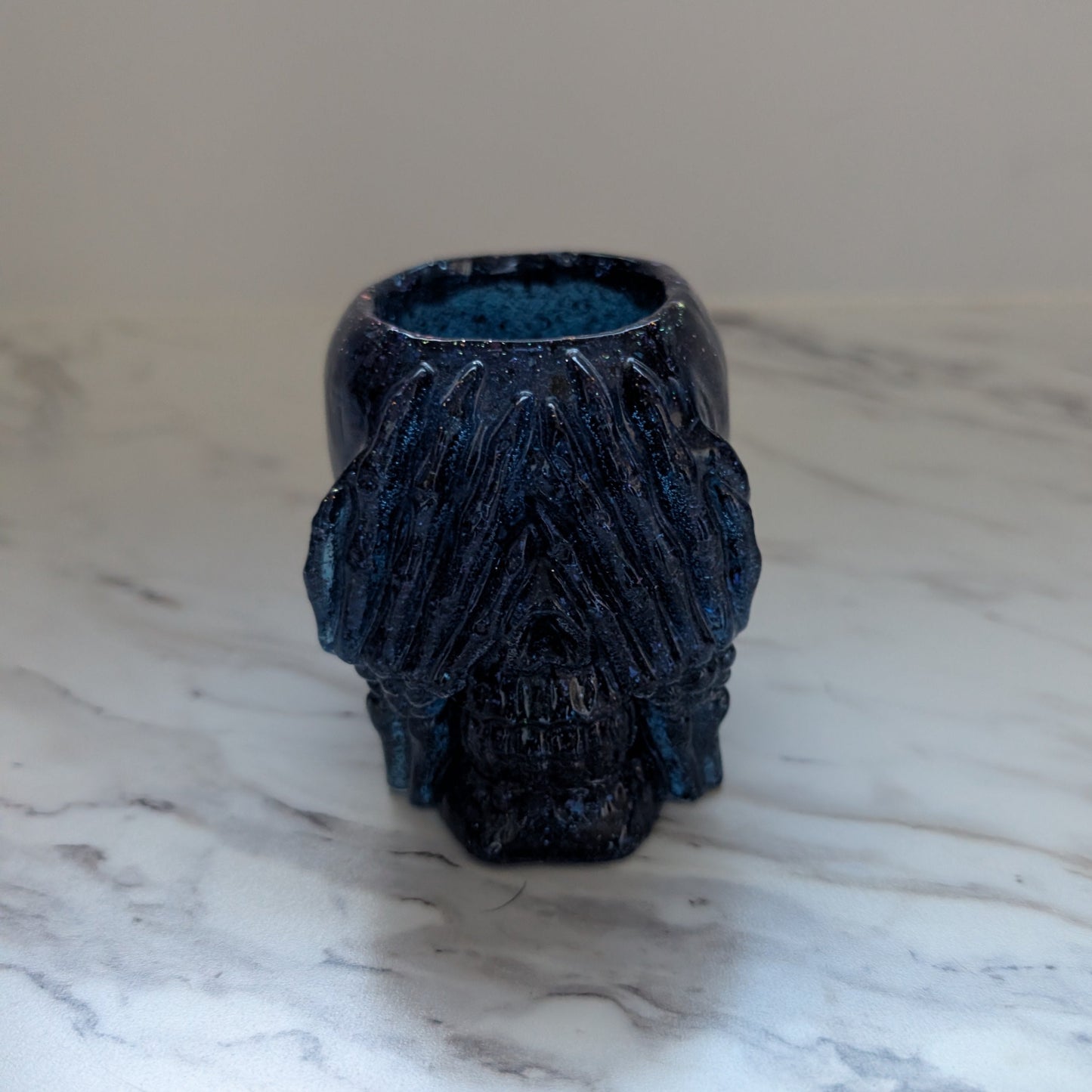Blue textured skull-shaped trinket holder on a marble surface