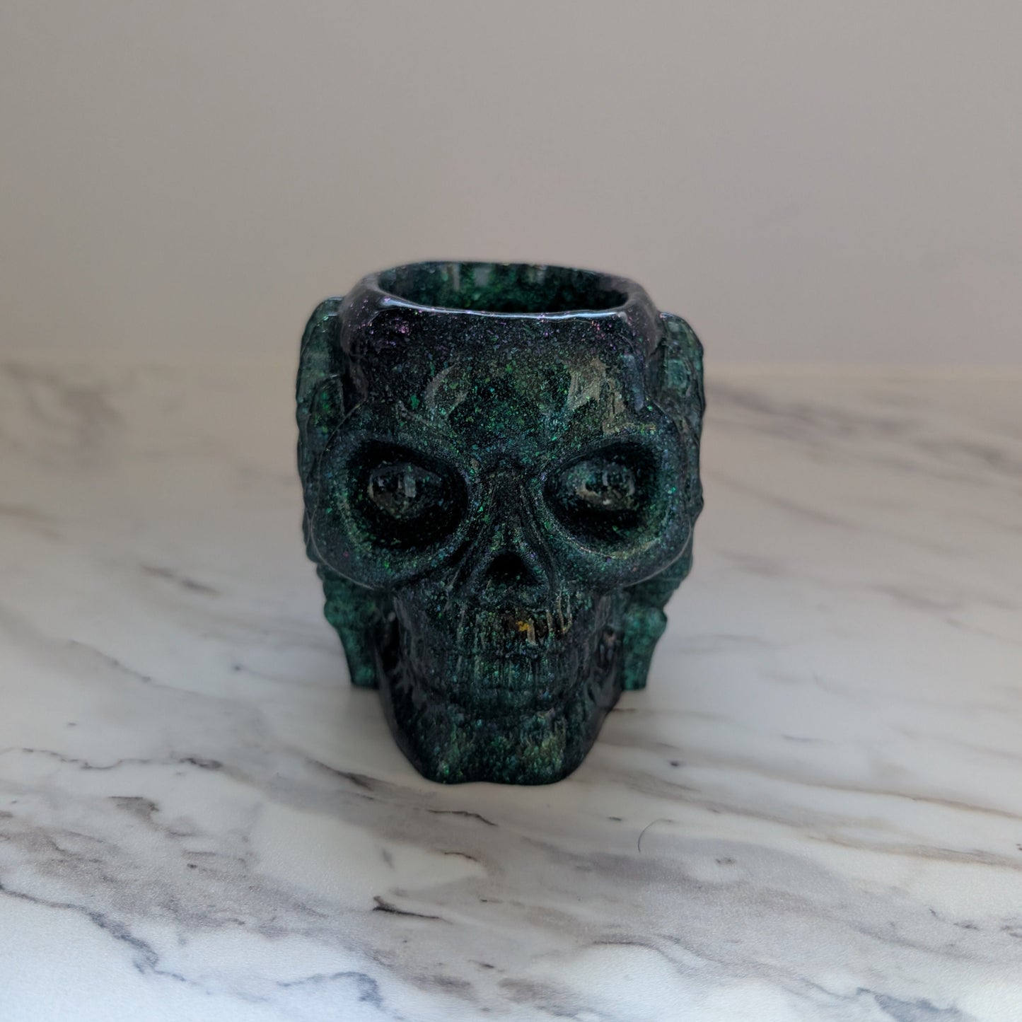 Skull-shaped trinket holder on a marble surface with a neutral background