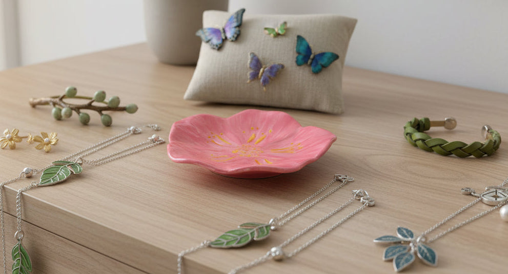Jewelry including necklaces, bracelets, and earrings on a wooden surface with a pink flower dish.