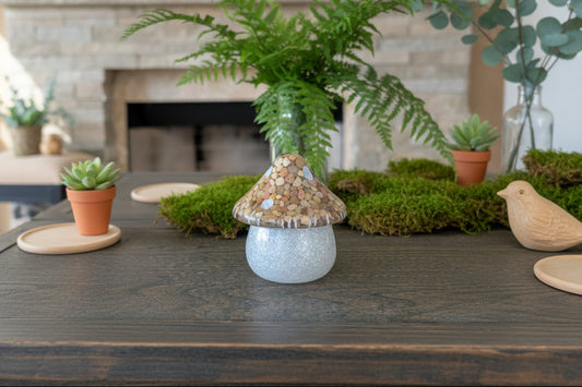 Decorative mushroom on a wooden surface with plants and a fireplace in the background