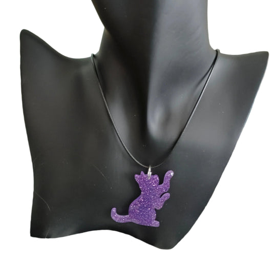 Unleash your inner feline with our stunning 17.5 inch black waxed cord necklace featuring a sleek resin cat pendant. Perfect for adding a touch of edgy elegance to any outfit, this necklace is both versatile and stylish. Upgrade your jewelry collection today!