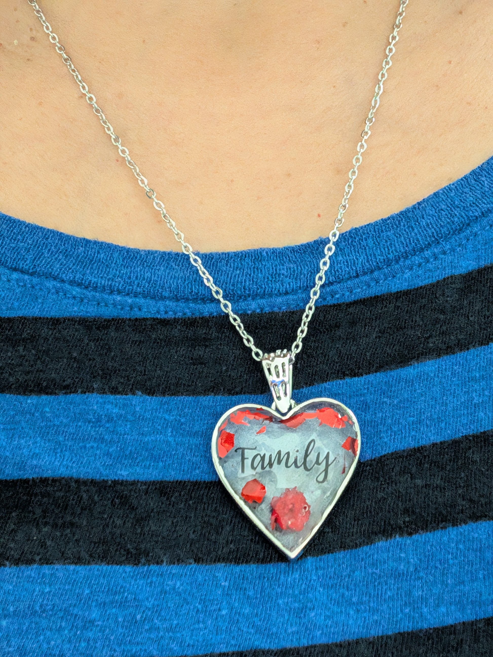 This stunning necklace features a 21-inch stainless steel cable link chain adorned with a beautiful family resin and flowers silver heart pendant. The perfect length for any outfit, with the option to add an additional 2 inches for the perfect fit. Show your love and style with this unique piece!

Necklace - 21 inches stainless steel cable link chain with a family resin and flowers silver heart pendant