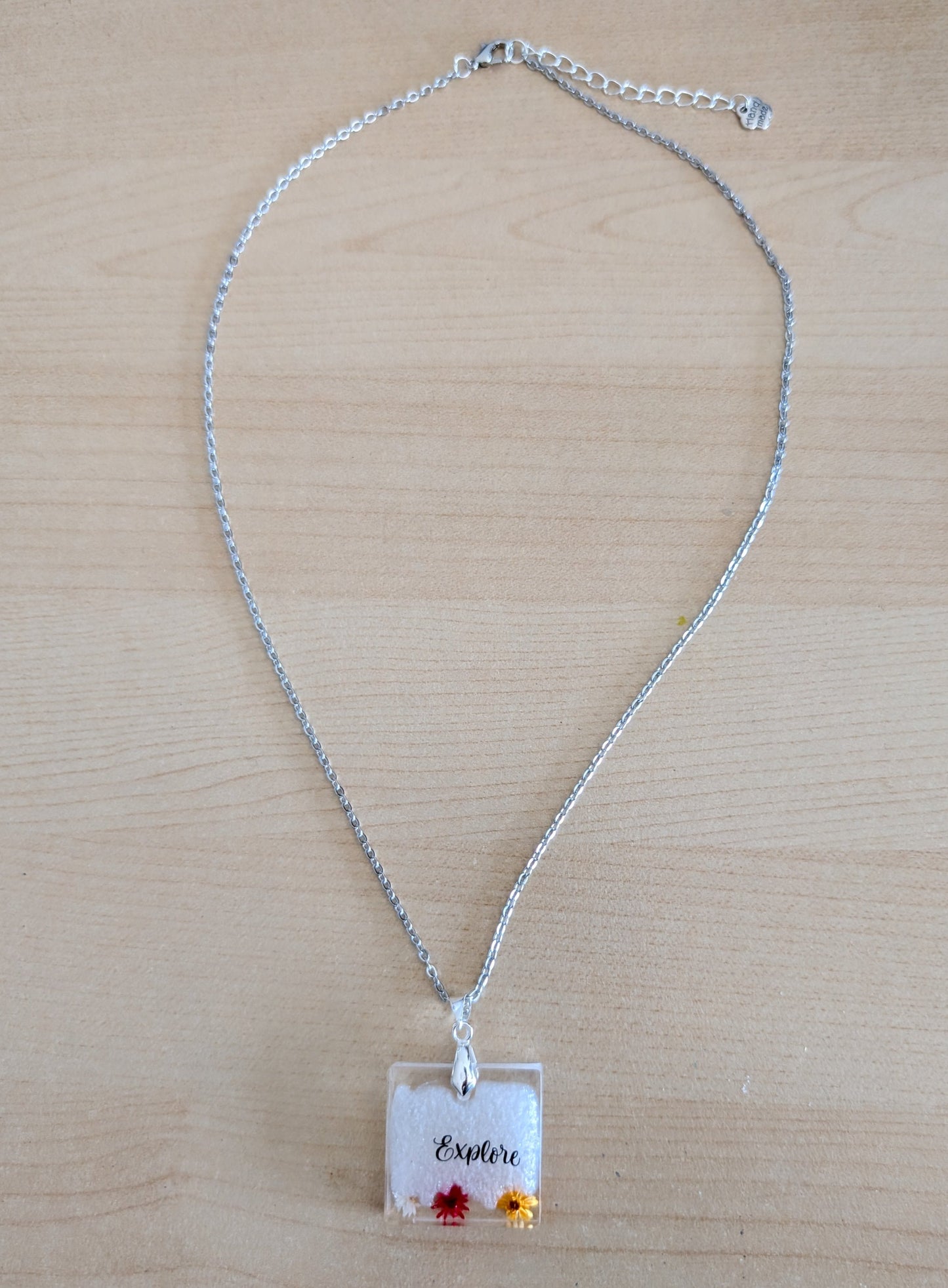 This stainless steel cable link chain necklace features a beautiful square pendant with real flowers embedded in resin. The necklace is 21 inches long, with an additional 2 inch extension chain. Make a statement with this one-of-a-kind piece!

Necklace - 21 inches stainless steel cable link chain with a resin with flowers square pendant
