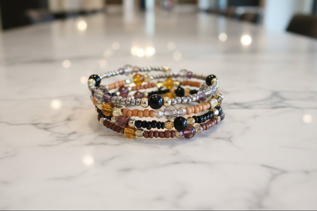 Experience the ultimate versatility and style with our 4 coil memory wire bracelet! Made with 6mm black and tan beads, accented by black, tan, and silver seed beads, and finished with eye-catching gold spacer beads. Elevate any outfit with this unique and effortless accessory.
