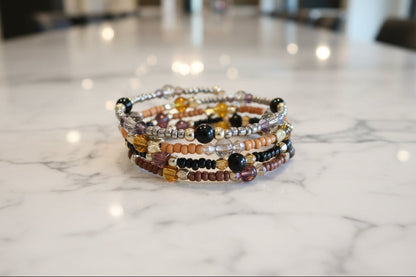 Experience the ultimate versatility and style with our 4 coil memory wire bracelet! Made with 6mm black and tan beads, accented by black, tan, and silver seed beads, and finished with eye-catching gold spacer beads. Elevate any outfit with this unique and effortless accessory.